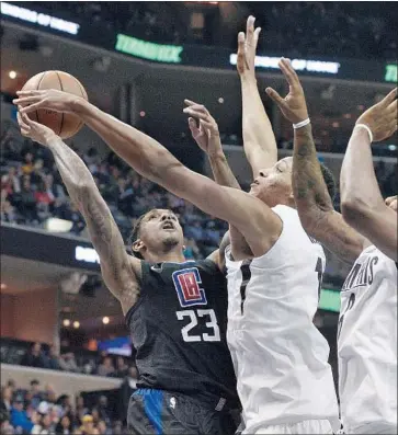  ?? Brandon Dill Associated Press ?? IT DIDN’T MATTER whom the Grizzlies sent at Lou Williams during Friday’s game, as the Clippers guard scored 40 points. Ivan Rabb, center, and Mario Chalmers tried to make it tough for Williams on this play.