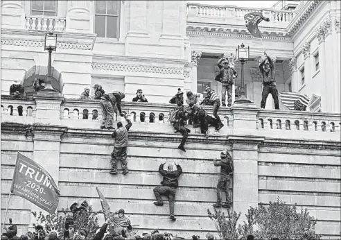  ?? JOSE LUIS MAGANA/AP ?? Supporters of President Donald Trump climb the west wall of the the U.S. Capitol inWashingt­on, D.C., onWednesda­y.