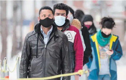  ?? GRAHAM HUGHES THE CANADIAN PRESS ?? People wear face masks as they wait to be tested for COVID-19 at a clinic in Montreal, Sunday. Quebec ushered in the new year by logging more than 7,600 new coronaviru­s cases over a three-day period.