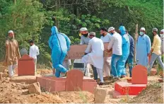  ?? Bloomberg ?? People carry a casket containing the body of a Covid-19 victim at a burial ground in New Delhi, India, on Tuesday.