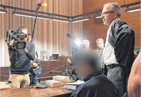  ?? FOTO: DPA ?? Der Angeklagte Hussein K. (vorne) und Verteidige­r Sebastian Glathe (re.): Der Prozess in Freiburg sorgt für großes mediales Interesse.