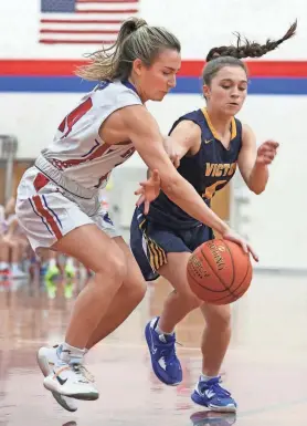  ?? PHOTOS BY SHAWN DOWD/DEMOCRAT AND CHRONICLE ?? Fairport's Livea Amadori (14), left, goes for the steal on Victor's Allie Pisano (4), right, in the first half during their Section V game Friday, Dec. 9, 2022 at Fairport High School. Fairport won 57-43.