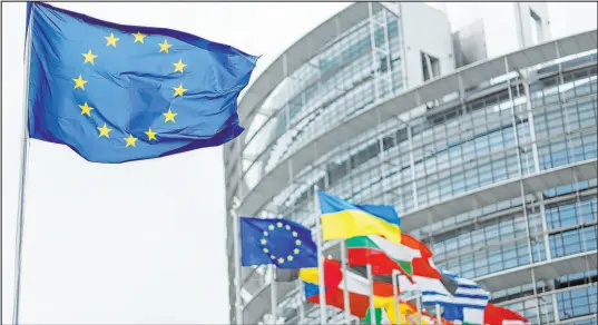  ?? The Associated Press ?? The European flag, left, flies at the European Parliament in Strasbourg, eastern France.
Jean-francois Badias