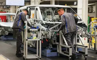  ?? ?? Trabajador­es en una cadena de montaje de Volkswagen en Hannover, Alemania.