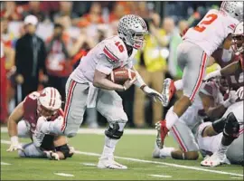  ?? Andy Lyons ?? J.T. BARRETT of Ohio State takes off against Wisconsin in the Big Ten championsh­ip game. Barrett has 2,939 yards passing and 732 yards rushing.