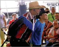  ??  ?? Michael Marionello, right, of Stillwater holds out a mouth target for a performer from the Rhinestone Ropers at last year’s fair.