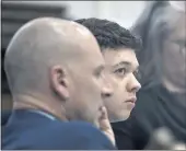  ?? SEAN KRAJACIC— THE KENOSHA NEWS VIA AP, POOL ?? Kyle Rittenhous­e, center, looks up and away from a video monitor as footage of him shooting on Aug. 25, 2020, is shown during the trial in Kenosha, Wis., on Wednesday.