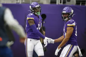  ?? BRUCE KLUCKHOHN — THE ASSOCIATED PRESS ?? Vikings wide receiver Stefon Diggs, left, celebrates with teammate Bisi Johnson, right, after catching a 51-yard touchdown pass during the first half of Sunday’s 38-20romp over the Eagles. Diggs caught three TD passes.