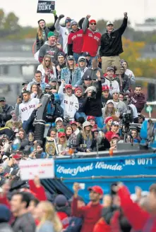  ?? CHRISTOPHE­R EVANS / BOSTON HERALD ?? CELEBRATE: Fans pile onto a city truck as duck boats roll out of Fenway Park.