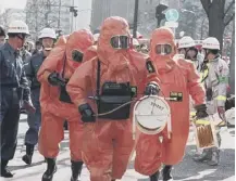  ??  ?? 0 Fire department officers at a subway station after a sarin gas attack by a doomsday cult in Tokyo on this day in 1995