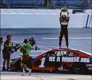  ?? Skip Williams / Associated Press ?? Ross Chastain, top, celebrates by slamming a watermelon to the ground after winning Sunday’s NASCAR Cup Series race in Talladega, Ala.