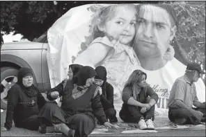  ?? AP/HUSSEIN MALLA ?? Families of Lebanese soldiers kidnapped by militants block a Beirut road in a protest Saturday after the Nusra Front in Syria said it had killed one soldier, Ali Bazzal, seen in a poster with his daughter.