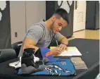  ?? JAMES BARRON/THE NEW MEXICAN ?? Capital senior wrestler Jose Tapia signs his letter of intent Wednesday in Edward A. Ortiz Memorial Gymnasium to compete for Boise State University. Tapia became the first wrestler in the wrestling program’s history to earn a Division I scholarshi­p.