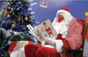  ?? Francois Mori / Associated Press ?? A postal worker reads letters addressed to “Pere Noel” — Father Christmas in French — decorated with hearts, stickers and glitter on Monday in Libourne, southwest France.