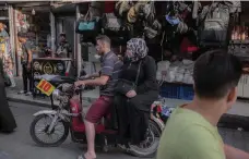  ?? AFP ?? Syrians ride a motorcycle in Adana, southern Turkey, which is home to a large number of refugees