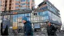  ?? GETTY IMAGES ?? Women pass by the apartment block in Lobanovsky Ave in Kiev which was hit by a Russian missile on February 26.