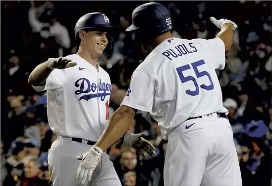  ?? MARCIO JOSE SANCHEZ — THE ASSOCIATED PRESS ?? The Dodgers’ Will Smith, left, is greeted by Albert Pujols after Smith hit a two-run home run to score Corey Seager during the eighth inning of Game 4 against the Giants.