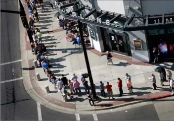  ??  ?? In this Thursday photo, hopeful eclipse-watchers line up outside the Clark Planetariu­m in hopes of getting eclipse glasses from the gift shop in Salt Lake City. Eclipse mania is building and so is demand for the glasses that make it safe to view the...