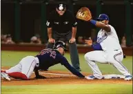  ?? LM Otero / Associated Press ?? The Red Sox’s Enrique Hernandez dives back to first base, beating the pickoff throw to Rangers first baseman Andy Ibanez, as umpire Brian Knight watches during the fourth inning Saturday.