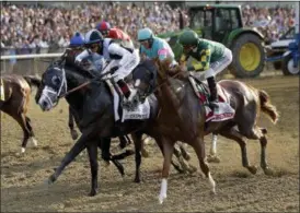  ?? JULIO CORTEZ - THE ASSOCIATED PRESS ?? Tapwrit, ridden by Jose Ortiz, left, in black and white, and Irish War Cry, ridden by Rajiv Maragh, right, in green and yellow, race at the start of the 149th running of the Belmont Stakes June 10 in Elmont, N.Y. Tapwrit won for one of Ortiz’s 65...