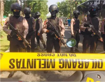  ?? AP FOTO ?? SUNDAY ATTACK. Police officers stand guard near the site where suicide bombers on motorcycle attack Santa Maria Church in Surabaya, East Java, Indonesia yesterday.