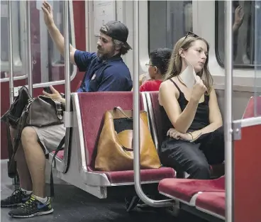  ?? TYLER ANDERSON / NATIONAL POST ?? A women fans herself on one of the “hot cars” without air conditioni­ng on the Bloor-Danforth subway line. The TTC says it is working to deal with the problem.