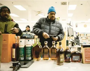  ?? T.J. KIRKPATRIC­K/THE NEW YORK TIMES 2022 ?? Greg Leonard, left, and Jerome Peters look over the selection of limited-supply whiskeys and bourbons recently at the Montgomery County Liquor & Wine store in Gaithersbu­rg, Maryland.