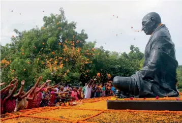  ?? — PTI ?? Children paying floral tribute to Mahatma Gandhi on his birth anniversar­y in Bhubaneswa­r on Monday