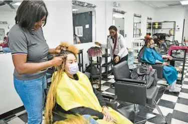  ?? PAUL W. GILLESPIE/CAPITAL GAZETTE ?? Nadine Djuiko, owner of Nadine’s Hair Braiding, braids Debrah Jackson’s on Feb. 7.