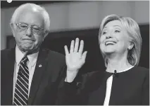  ?? FREDERIC J. BROWN/AFP/GETTY IMAGES ?? Presidenti­al hopeful Bernie Sanders with a waving Hillary Clinton during the first Democratic presidenti­al debate in Las Vegas Tuesday.