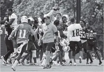  ?? THE ASSOCIATED PRESS ?? Tennessee Titans coach Mike Mularkey, center, walks off the field as players celebrate after beating the coaches in a high-speed punt, pass and kick competitio­n during the team’s minicamp Thursday in Nashville.