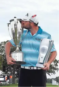  ?? BRIAN SPURLOCK / USA TODAY SPORTS ?? Marc Leishman kisses the Wadley Trophy and holds the BMW Championsh­ip Trophy after shooting a tournament-record 23-under par.