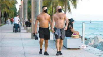  ?? MARIE-FRANCE COALLIER LE DEVOIR ?? Torses nus, Simone Onnis (à gauche) et Derek Yarbrough (à droite) détonnent avec leurs masques pendant leur promenade sous les palmiers du South Pointe Park Pier. « Trois membres de ma famille ont eu la COVID-19 », explique Derek Yarbrough.
« Je trouve ça stupide que ça devienne un enjeu politique. »