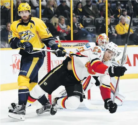  ?? THE ASSOCIATED PRESS ?? Predators winger James Neal shoves Calgary defenceman Dougie Hamilton to the ice during the second period Thursday in Nashville. Hamilton scored for the Flames to take some measure of revenge, but the visitors suffered their second straight loss on the...