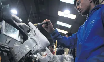  ?? AFP ?? An employee works at a factory of Nepali shoe brand Goldstar in Kathmandu.