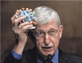  ?? GRAEME JENNINGS/POOL PHOTO ?? Dr. Francis Collins, here holding a model of the coronaviru­s while testifying in 2020 as director of the National Institutes of Health, has been publicly reflecting on the mistakes made by the public health establishm­ent during the COVID-19 pandemic.
