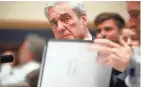  ?? ALEX BRANDON/AP ?? Former special counsel Robert Mueller checks pages in his report on Russian election interferen­ce as he testifies Wednesday.