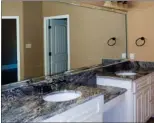  ??  ?? Along with a jetted tub and a tile and glass shower, the master bath offers a granite-topped vanity.