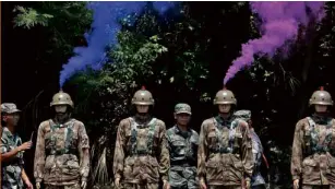  ?? REUTERS ?? SMOKE comes out from the helmets of dummies beside People’s Liberation Army soldiers during a mock shooting practice in Hong Kong on July 1.