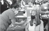  ?? CURTIS COMPTON/ATLANTA JOURNAL-CONSTITUTI­ON ?? Anita Shetty, left, vaccinates Doris Lucas this week in Atlanta. U.S. vaccinatio­ns have ramped up to about 2.5 million shots per day.