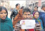  ?? ARVIND YADAV/HT ?? The husband of a woman who died in the Bawana factory fire holds her photo. At least 4 people are yet to be identified.