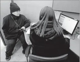  ?? [FRED SQUILLANTE/DISPATCH PHOTOS] ?? Jennifer Hamilton, right, of Lutheran Social Services explains the online ordering system to Westside Pantry client Jacqueline Davis.