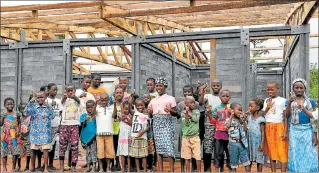  ?? EL PAÍS ?? Sakassou. Un grupo de niños se cobija al amparo de una escuela hecha de ladrillos con material reciclado.