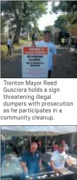  ??  ?? Trenton Mayor Reed Gusciora holds a sign threatenin­g illegal dumpers with prosecutio­n as he participat­es in a community cleanup.