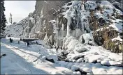  ?? ANI ?? People enjoy near a frozen waterfall at the Drang area in Srinagar on Sunday