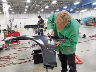  ?? CONTRIBUTE­D PHOTOS BY MIKE MOORE ?? Students pound out dents from a fender during the collision repair portion of the regional SkillsUSA competitio­n recently.