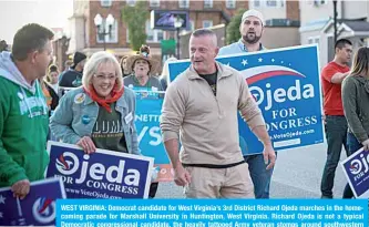  ?? —AFP ?? WEST VIRGINIA: Democrat candidate for West Virginia’s 3rd District Richard Ojeda marches in the homecoming parade for Marshall University in Huntington, West Virginia. Richard Ojeda is not a typical Democratic congressio­nal candidate, the heavily tattooed Army veteran stomps around southweste­rn West Virginia in tight Grunt Style t-shirts, tactical pants and combat boots.