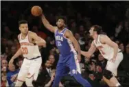  ?? SETH WENIG — THE ASSOCIATED PRESS ?? Sixers center Joel Embiid looks for a pass as Kevin Knox, left, and Luke Kornet of the Knicks defend Sunday afternoon in a 108-105 Sixers win.