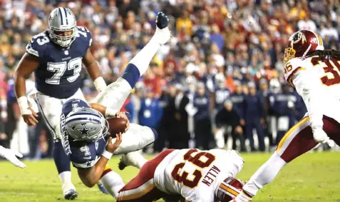 ?? Andrew Harnik/Associated Press ?? ■ Dallas Cowboys quarterbac­k Dak Prescott (4) dives over Washington Redskins defensive end Jonathan Allen (93) for a touchdown Sunday in Landover, Md.
