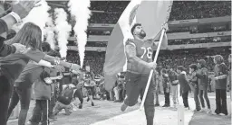  ?? ROB SCHUMACHER/THE REPUBLIC ?? Cardinals guard Will Hernandez (76) carries the Mexican flag onto the field prior to the game against the 49ers in Mexico City.